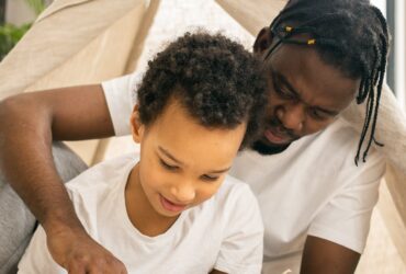 father teaching child to read