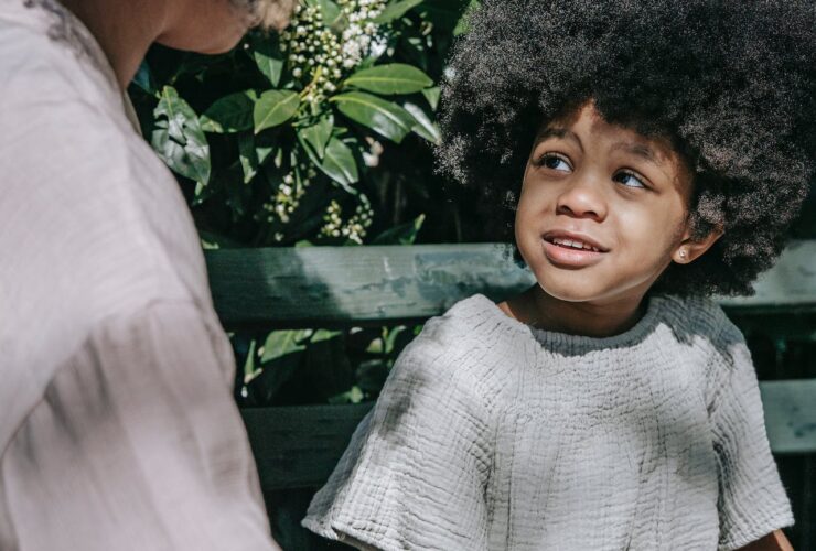 boy sitting on a bench talking to his mother