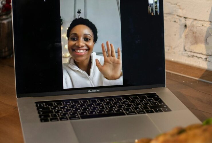 showing a computer screen with a woman waving