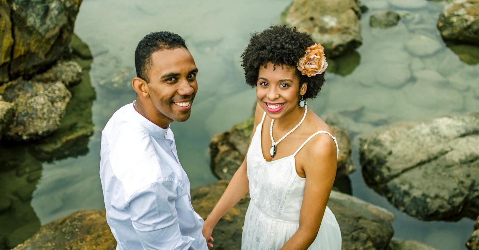 Smiling couple in white holding hands