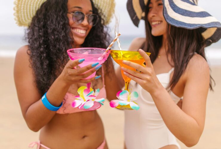 Women on beach holding drinks