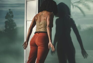 Stressed woman leaning her head on a glass door