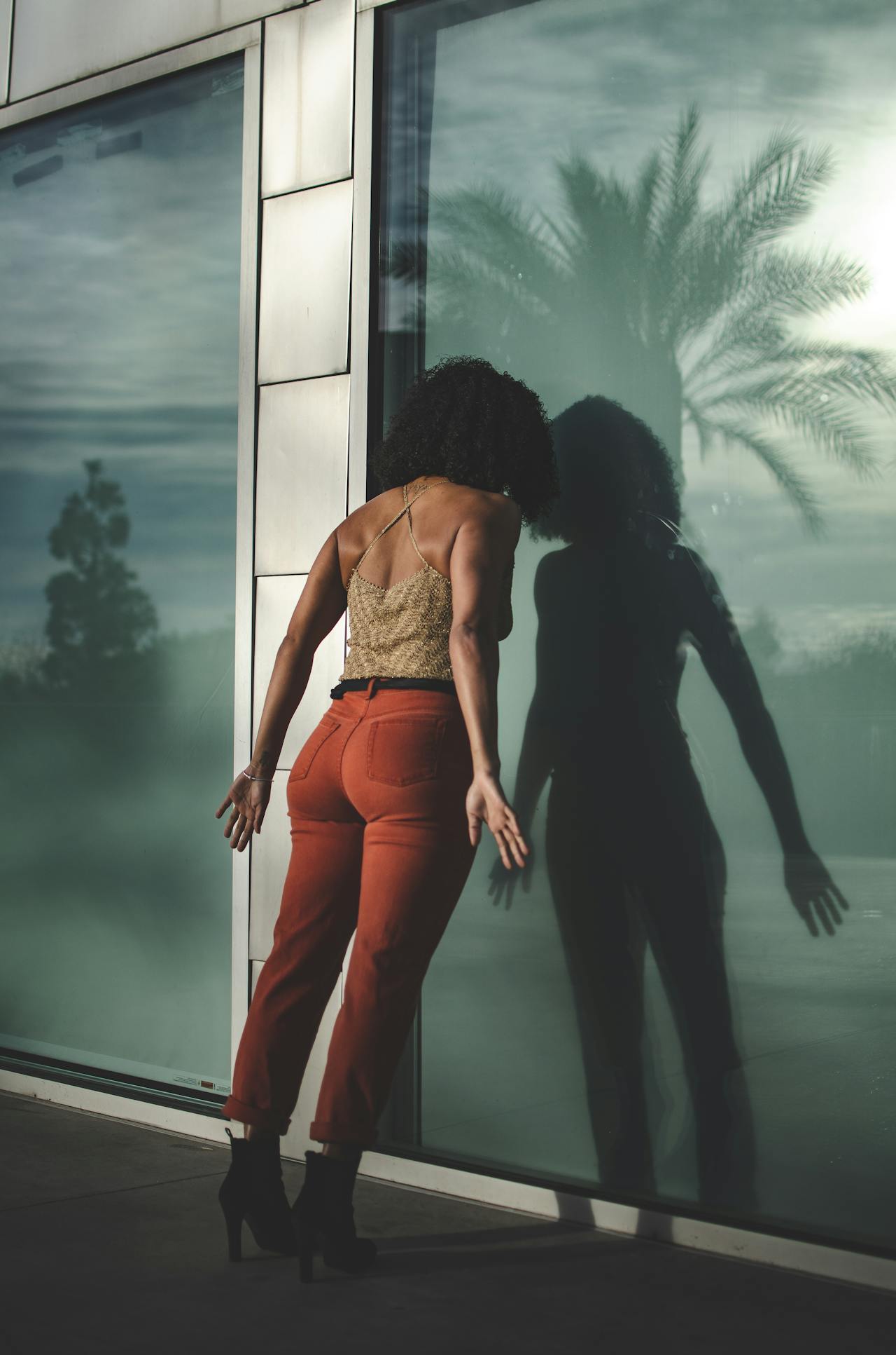 Stressed woman leaning her head on a glass door